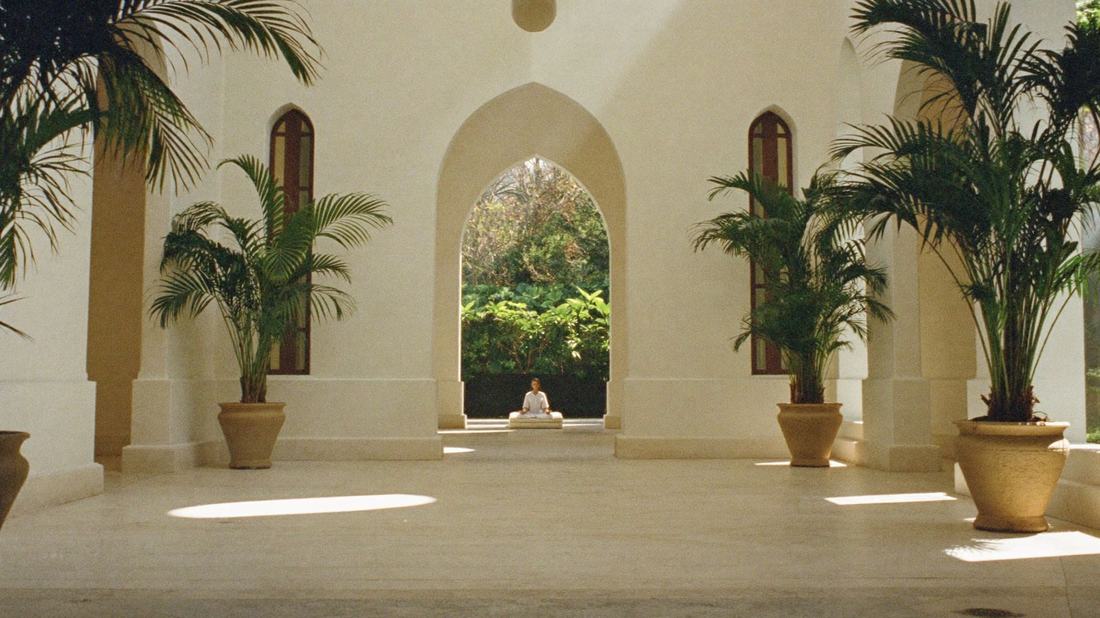 Heller Tempelsaal mit Bögen und Palmen, Blick in einen Garten